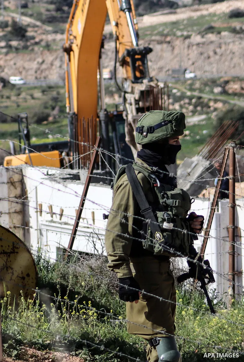 Israeli forces stand guard as Israeli machinery demolish a Palestinian house (still under construction) located within the area C (where Israel retains control, including over planning and construction) southeast of Hebr...
