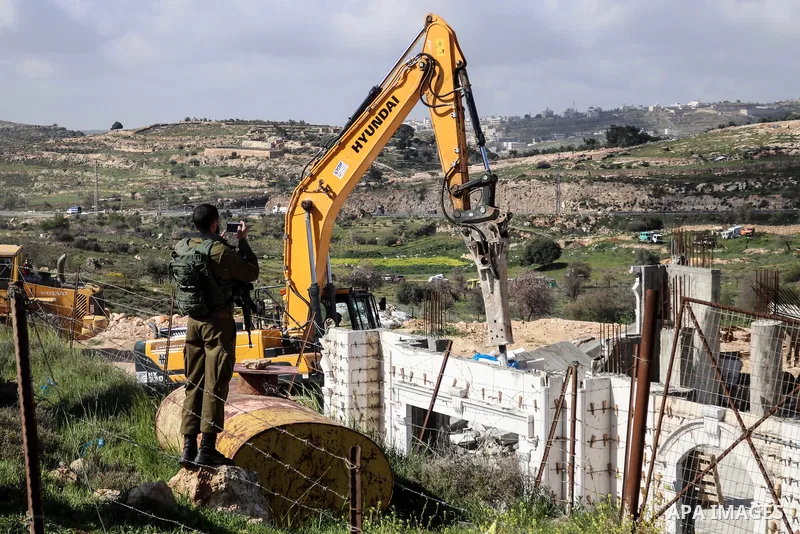 Israeli forces stand guard as Israeli machinery demolish a Palestinian house (still under construction) located within the area C (where Israel retains control, including over planning and construction) southeast of Hebr...