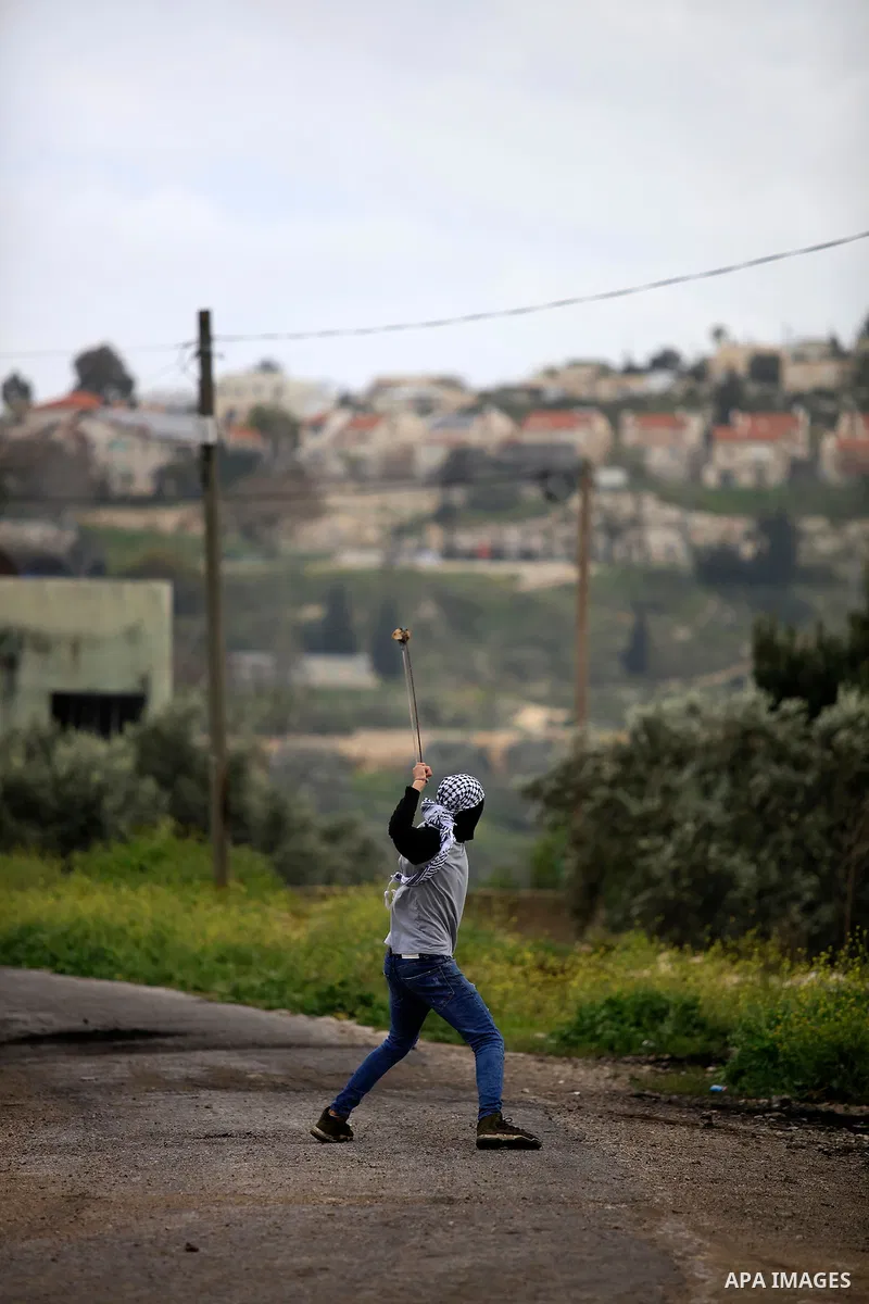 Palestinian protesters hurl a stones towards Israeli forces during clashes following a weekly demonstration against the expropriation of Palestinian land by Israel in the village of Kfar Qaddum, near the West Bank city o...