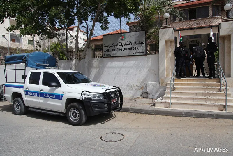 Policemen stand guard as Palestinians begin registering party lists for May parliamentary election, at the Central Elections Commission's office in Gaza City March 20, 2021. Farid Taamallah, a spokesman of the Palestinia...