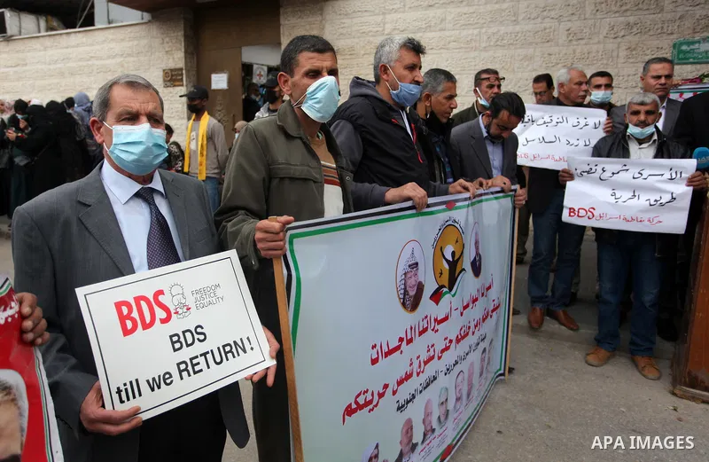 Palestinians take part in a protest to show solidarity with prisoners and the spread of the coronavirus disease (COVID-19) on Israeli Jails, in front of the headquarters of Red cross in Gaza city, on March 22, 2021. With...