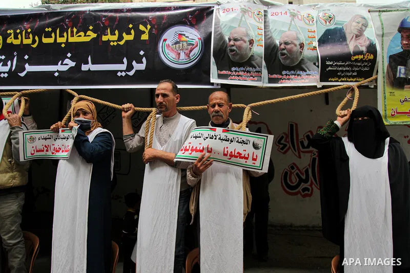Families of Palestinian martyrs and wounded, take part in a protest tent against the Palestinian Authority's decision to cut their salaries for seven years, in Gaza city, on March 23, 2021. "The leaders agreed on the sol...