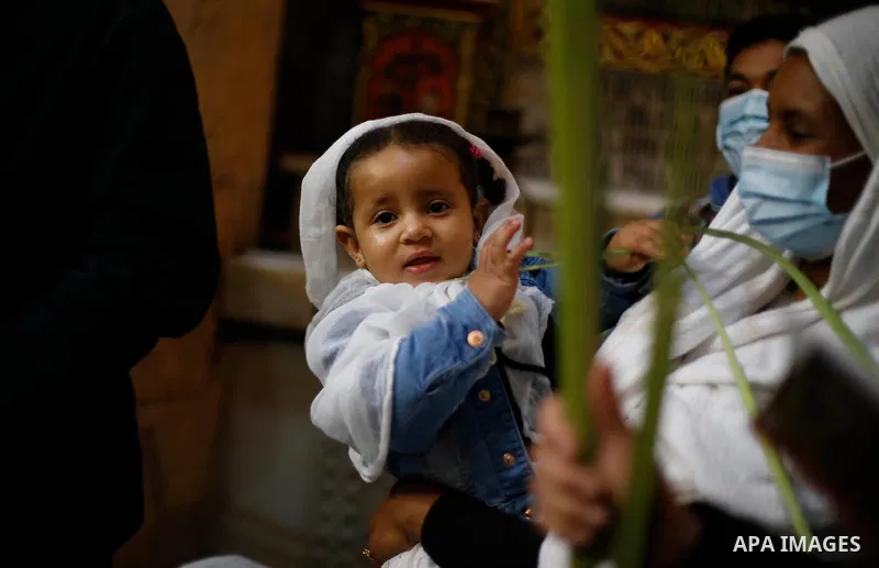 Christian worshippers hold palm fronds during a Palm Sunday procession in the Church of the Holy Sepulchre in Jerusalem's Old City March 28, 2021. Palm Sunday, which is the biblical account of Jesus Christ's entry into J...