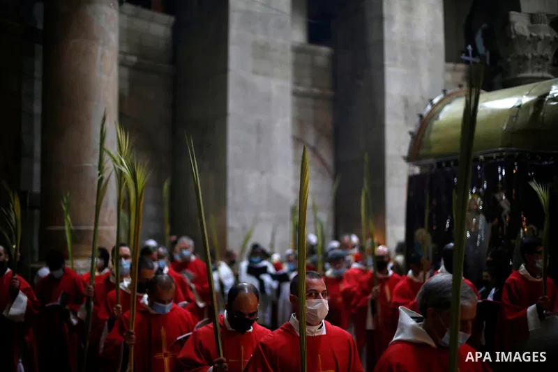 Christian worshippers hold palm fronds during a Palm Sunday procession in the Church of the Holy Sepulchre in Jerusalem's Old City March 28, 2021. Palm Sunday, which is the biblical account of Jesus Christ's entry into J...