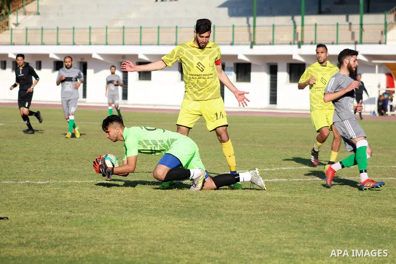 Palestinian football players of Khadamat Al Nuseirat(yellow) and Almojama Al islame(grey) compete during the first division League ​at Yarmouk Stadium, in Gaza City on March 29, 2021. Photo by Marihan Al-Khalidi