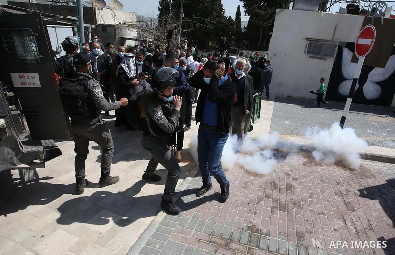 Palestinian demonstrators react to a sound grenade fired by Israeli forces during a protest marking "Land Day", in Sebastia near Nablus, in the Israeli-occupied West Bank March 30, 2021. The participants in the rally cal...