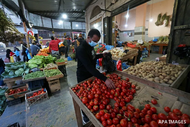 Palestinians shop at a market in Deir Al-Balah in the center of the Gaza Strip, on April 1, 2021. The Ministry of Interior and National Security has taken a set of measures that will start to be implemented tomorrow, Fri...