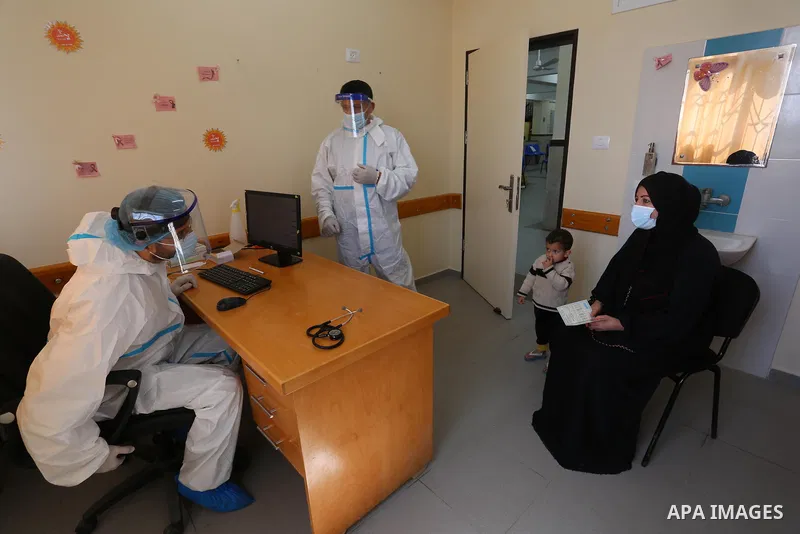 UNRWA employees wear face masks as the provide services, amid the spread of the Coronavirus COVID-19, in a UN clinic in Deir El-Balah, in the center of the Gaza Strip, on April 3, 2021. President Mahmoud Abbas today issu...