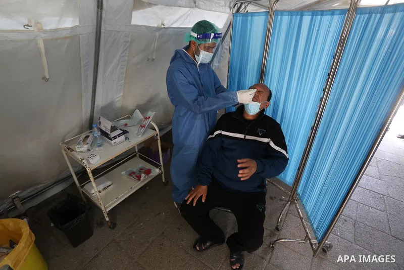A Palestinian health worker collects a swab sample from a person for Covid-19 test in Deir al-Balah in the central Gaza Strip, on April 8, 2021. Hospitals in the Palestinian Territories of the West Bank and Gaza are bein...
