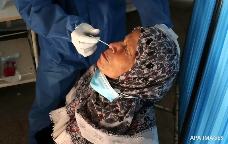 A Palestinian health worker collects a swab sample from a person for Covid-19 test in Deir al-Balah in the central Gaza Strip, on April 8, 2021. Hospitals in the Palestinian Territories of the West Bank and Gaza are bein...
