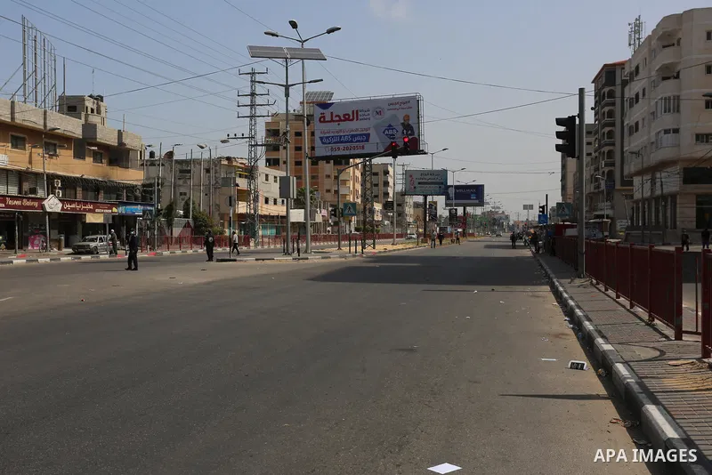 Palestinian policemen wear face masks, guard a barrier blocking a road, in Deir al-Balah in the central Gaza Strip, on April 8, 2021. Hospitals in the Palestinian Territories of the West Bank and Gaza are being overwhelm...