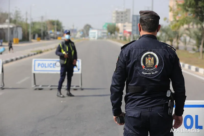 Palestinian policemen wear face masks, guard a barrier blocking a road, in Deir al-Balah in the central Gaza Strip, on April 8, 2021. Hospitals in the Palestinian Territories of the West Bank and Gaza are being overwhelm...