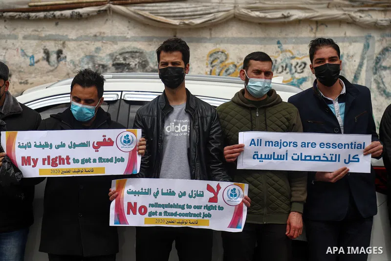 Palestinian teachers take part in a protest demanding their rights in front of the headquarters United Nations Relief and Works Agency (UNRWA), in Gaza City on April 11, 2021. The teachers in the United Nations Relief an...