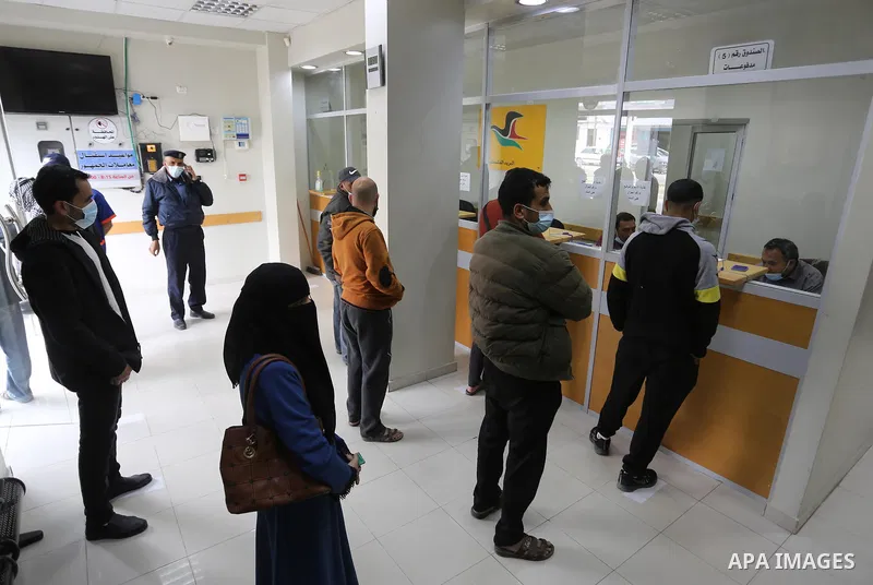 Palestinians wear protective face masks, as they wait to receive their financial aid, amid the coronavirus disease (COVID-19) outbreak, at the Post Office, in Dair Al Balah in the central of Gaza Strip, on April 10, 2021...