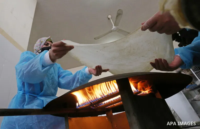 Palestinian women wear protective and maskes prepare traditional food of Couscous "Maftoul", samosa and Kubba in Khan Younis in the southern Gaza Strip, on April 11, 2021 to sell it to customers a head of Islamic holy mo...