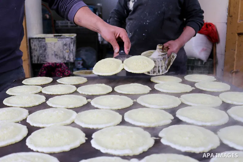 Palestinian vendors prepare ''Qatayef'', traditional pancakes that are popular at a market ahead the Muslim holy month of Ramadan, amid the coronavirus disease (COVID-19), in the West Bank city of Hebron, on April 11, 20...