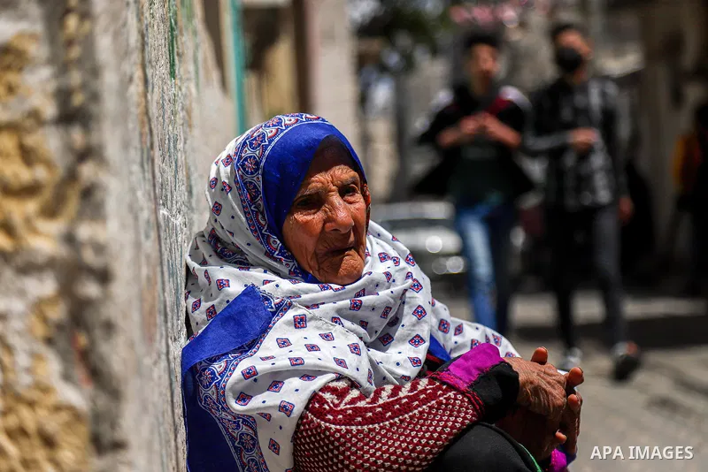 A Palestinian woman sit on the street in Rafah in the southern Gaza Strip on April 12, 2021. Photo by Mohammed Salem