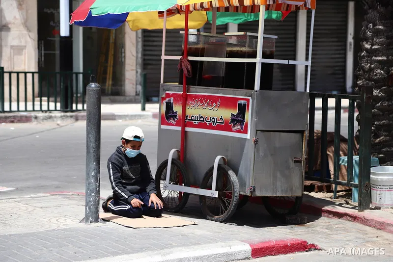 A Palestinian boy perform Friday prayer beside his carob cart during lockdown following the outbreak of the coronavirus disease (COVID-19), in Gaza city, on April 23, 2021. Ahead of Ramadan, the authorities in Gaza Strip...