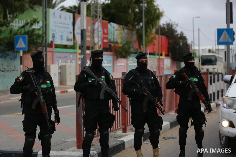 Members of Ezz-Al Din Al-Qassam Brigades, the armed wing of the Hamas movement, stand guard at a street in Deir Al-Balah refugee camp in the central Gaza Strip, on April 23, 2021. Photo by Ashraf Amra
