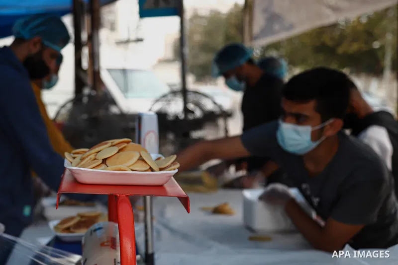 Abu Wisam Saqallah, a Paletsinian man prepares "Qatayef'' traditional pancakes that are popular on Muslim holy month of Ramadan with his family to sell it for customers in Gaza city on April 26, 2021. Celebrations in Gaz...