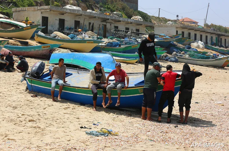 Palestinian fishermen sit on a beach, in Deir al-Balah in the center of Gaza strip, on April 29, 2021. Israel’s decision to reopen the fishing zone came hours before the Palestinian Authority was due to announce whether...