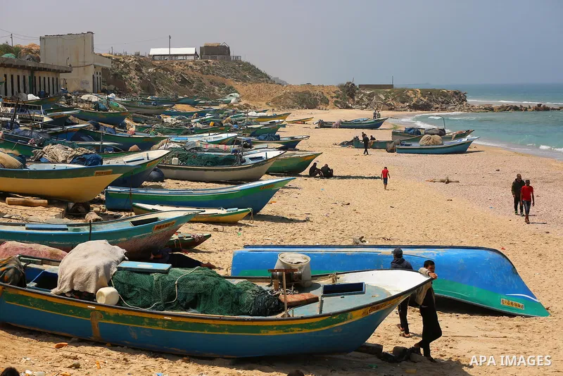 Palestinian fishermen sit on a beach, in Deir al-Balah in the center of Gaza strip, on April 29, 2021. Israel’s decision to reopen the fishing zone came hours before the Palestinian Authority was due to announce whether...