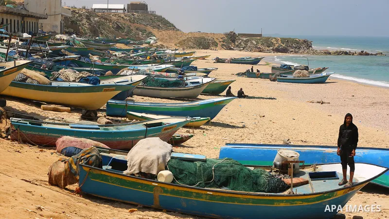 Palestinian fishermen sit on a beach, in Deir al-Balah in the center of Gaza strip, on April 29, 2021. Israel’s decision to reopen the fishing zone came hours before the Palestinian Authority was due to announce whether...