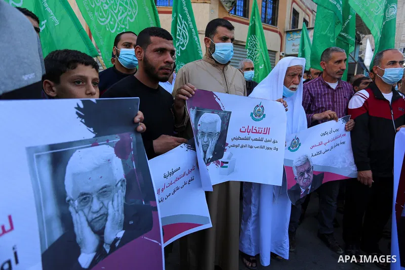 Palestinian supporters of Hamas movement demonstrate against postponement of the Palestinian parliamentary and presidential elections, calling for holding elections on planned date in Dair Al Balah in the central of Gaza...