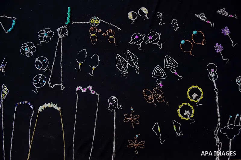 Palestinian artist, Farah Al-Ajl, 20, makes a handmade accessories from copper and aluminum, at her home, in Gaza city on May 4, 2021. Al-Ajl, is studying business administration, where she works in this profession to he...