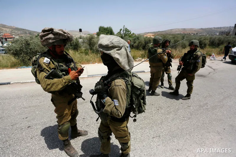 Israeli soldiers carry out a security operation in Aqraba village east of the West Bank city of Nablus, on May 4, 2021. Suspected Palestinian gunmen carried out a drive-by shooting at a nearby junction the previous, leav...