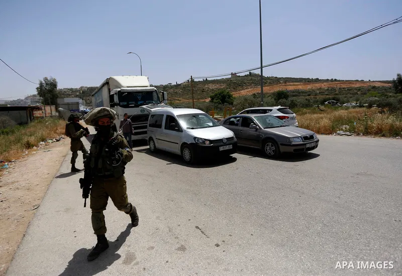 Israeli soldiers search cars during a security operation in Aqraba village east of the West Bank city of Nablus, on May 4, 2021. Suspected Palestinian gunmen carried out a drive-by shooting at a nearby junction the previ...