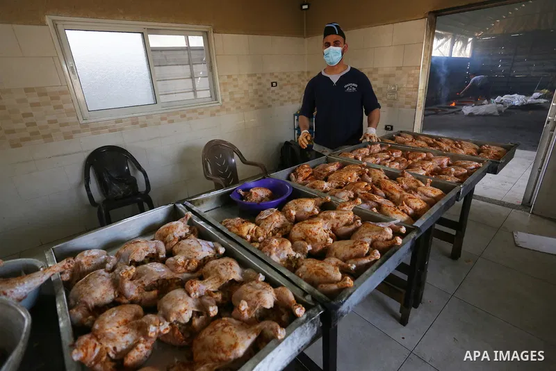 Palestinian chefs cook chickens and rice on firewood by burying them inside a barrel underground, to sell it to customers during the holy month of Ramadan in Deir al-Balah in the center of Gaza Strip, aimd the COVID-19 p...