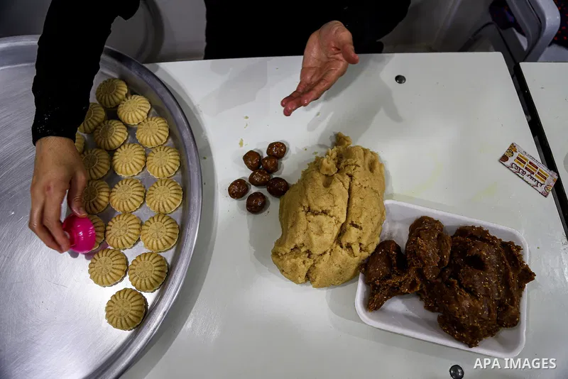 Palestinians prepare traditional date-filled mini cakes at factory, days before of Eid al Fitr in Gaza City amid the COVID-19 pandemic on May 05, 2021. People flock markets and shopping malls as they shop for food and ne...