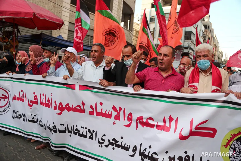 Palestinians take part during a protest against postponement of the Palestinian parliamentary and presidential elections, and against the forcible evictions of Palestinians from their homes in the Sheikh Jarrah neighborh...