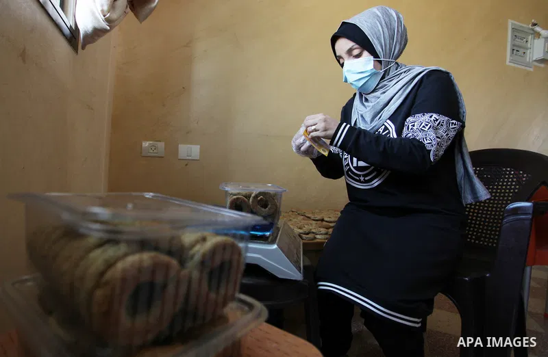 Palestinian women prepare traditional date-filled mini cakes, ahead of Eid al Fitr in Gaza City amid the COVID-19 pandemic on May 06, 2021. Eid al-Fitr this year is different in light of the COVID-19 pandemic. Eid al-Fit...