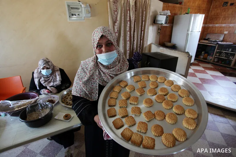 Palestinian women prepare traditional date-filled mini cakes, ahead of Eid al Fitr in Gaza City amid the COVID-19 pandemic on May 06, 2021. Eid al-Fitr this year is different in light of the COVID-19 pandemic. Eid al-Fit...