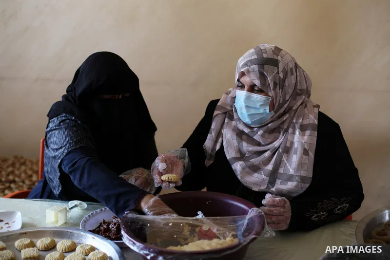 Palestinian women prepare traditional date-filled mini cakes, ahead of Eid al Fitr in Gaza City amid the COVID-19 pandemic on May 06, 2021. Eid al-Fitr this year is different in light of the COVID-19 pandemic. Eid al-Fit...