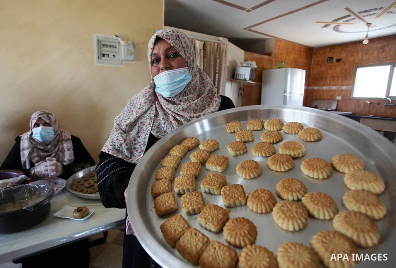 Palestinian women prepare traditional date-filled mini cakes, ahead of Eid al Fitr in Gaza City amid the COVID-19 pandemic on May 06, 2021. Eid al-Fitr this year is different in light of the COVID-19 pandemic. Eid al-Fit...