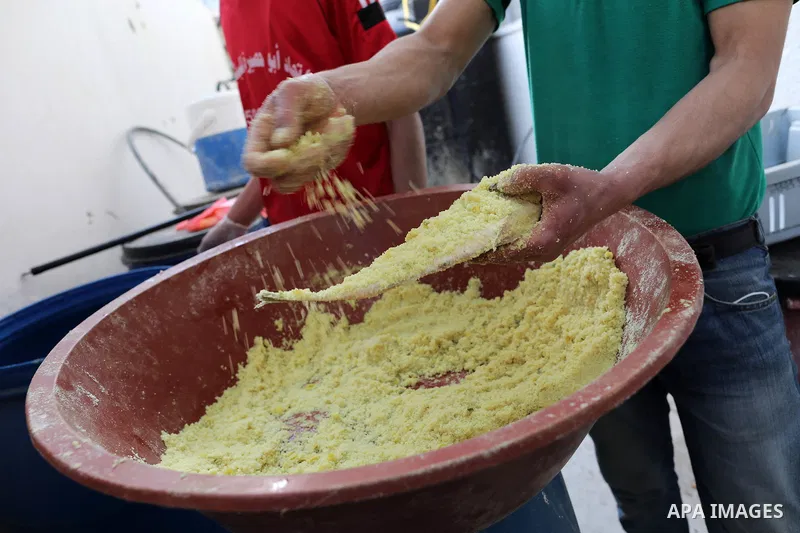 Palestinian men wearing masks, prepare salted fish to be sold in markets ahead Eid al Fitr holiday in Gaza City, on May 8, 2021. Salted fish, such as kippered herring or dried and salted cod, is fish cured with dry salt...
