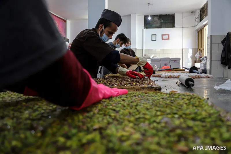 Palestinians prepare sweet known in Arabic as "Halkoum" to be sold ahead of the Eid al-Fitr holiday, at a factory in Gaza City on May 09, 2021. Eid al-Fitr this year is different in light of the COVID-19 pandemic. Eid al...