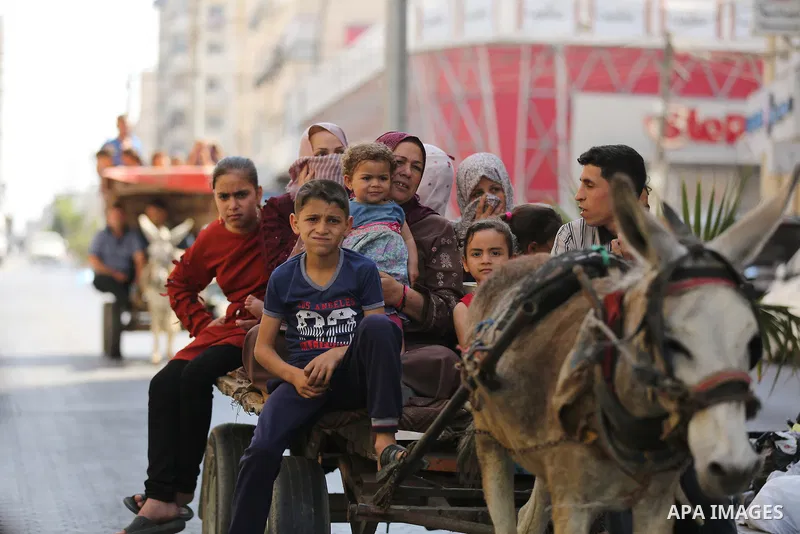 Palestinian families take shelter in a UN school in Gaza City after fleeing from their homes in the Shejaiya neighbourhood and the city of Beit Lahia during Israeli airstrikes, amid the escalating flare-up of Israeli-Pal...