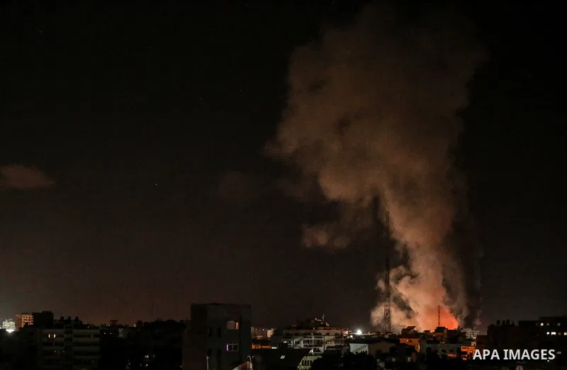 Fire and smoke rise above buildings in Gaza City as Israeli warplanes target the Palestinian enclave, on May 18, 2021. Photo by Bashar Taleb
