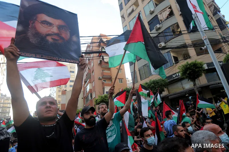 Lebanese and Palestinians shout slogans and wave flags, during a rally organized by Lebanon's militant Hezbollah group to express solidarity with the Palestinian people, in the southern suburb of Beirut, Lebanon, Monday,...