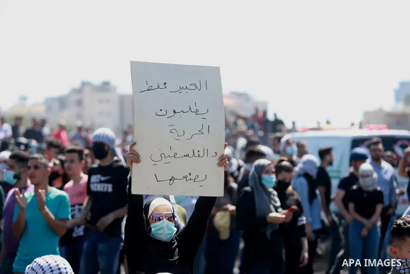 Palestinians protesting against Israel's occupation and its air campaign on the Gaza strip, shout slogans as they face Israeli troops near the settlement of Beit El and Ramallah in the occupied West Bank on May 18, 2021....