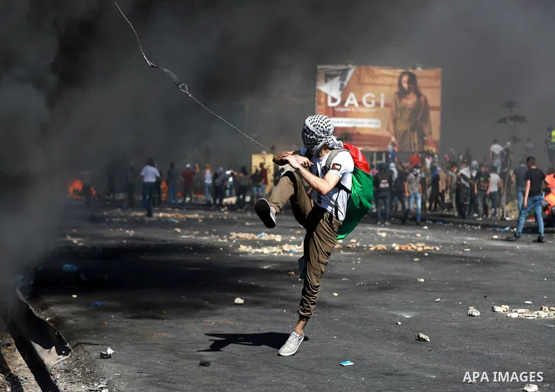 Palestinian protesters clash with Israeli soldiers against Israel's occupation and its air campaign on the Gaza strip near the settlement of Beit El and Ramallah in the occupied West Bank on May 18, 2021. Heavy air strik...