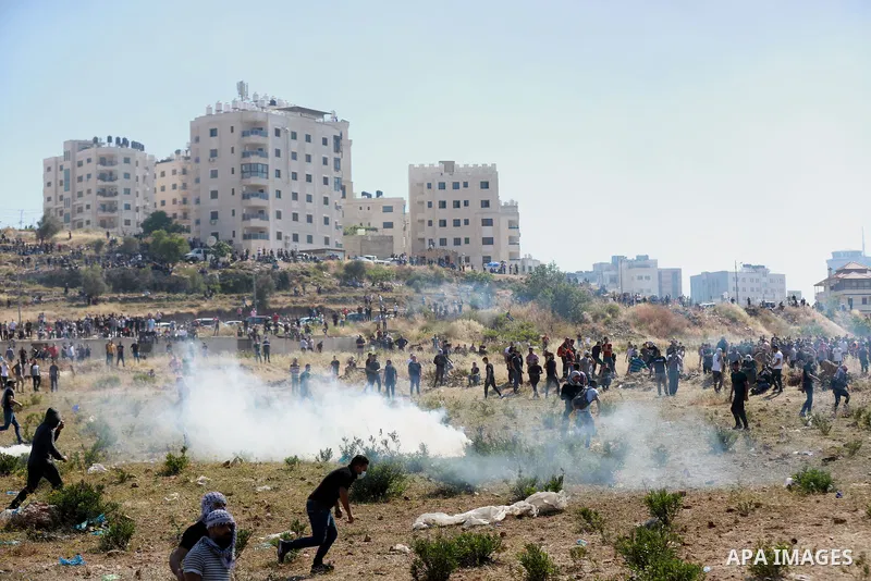Palestinian protesters clash with Israeli soldiers against Israel's occupation and its air campaign on the Gaza strip near the settlement of Beit El and Ramallah in the occupied West Bank on May 18, 2021. Heavy air strik...