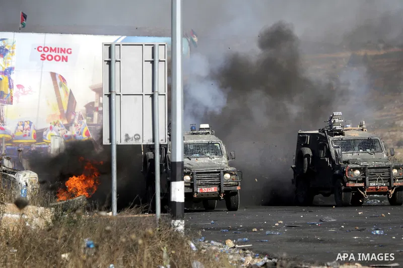 Palestinian protesters clash with Israeli soldiers against Israel's occupation and its air campaign on the Gaza strip near the settlement of Beit El and Ramallah in the occupied West Bank on May 18, 2021. Heavy air strik...