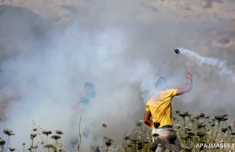 Palestinian protesters clash with Israeli soldiers against Israel's occupation and its air campaign on the Gaza strip near the settlement of Beit El and Ramallah in the occupied West Bank on May 18, 2021. Heavy air strik...