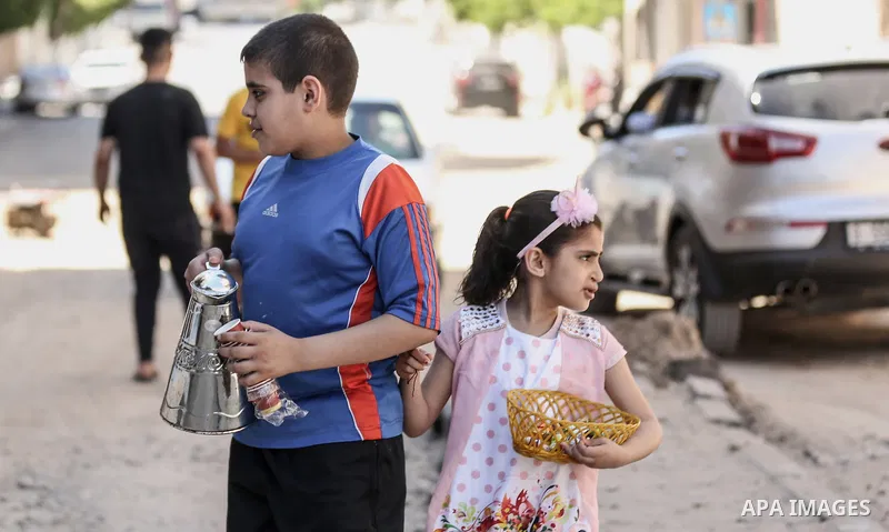Palestinian children, Mohammad and Sarah Abbas, distribute chocolate in front of their the rubble of a building amidst Israeli air strikes, in Gaza City May 18, 2021. Heavy air strikes and rocket fire in the Israel-Gaza...