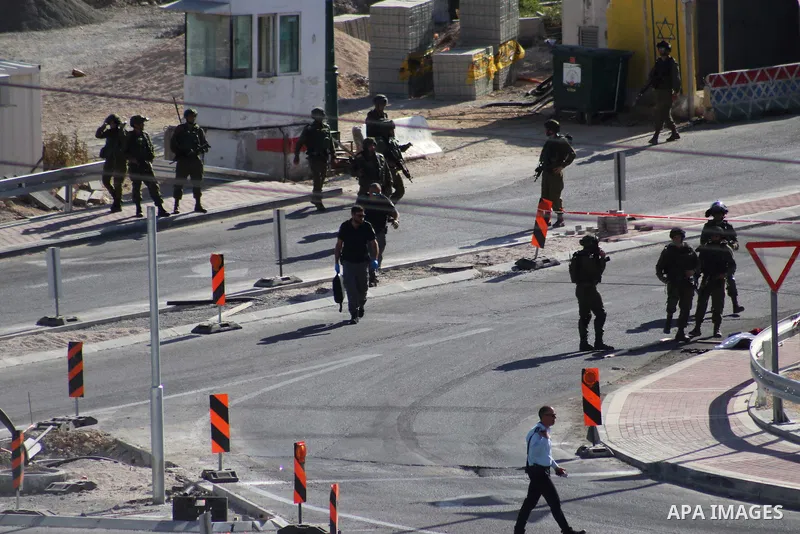 Israeli security forces gather at the scene where troops reportedly ahot and killed a Palestinain woman who they say approached the entrance of the Jewish settlement of Kiryat Arba'a with a gun and fired shots, in the We...